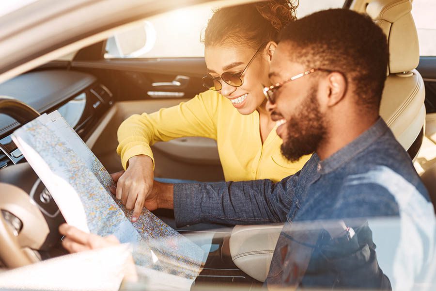 Blog - Young Couple Looking at a Map in Their Car Before Starting a Road Trip