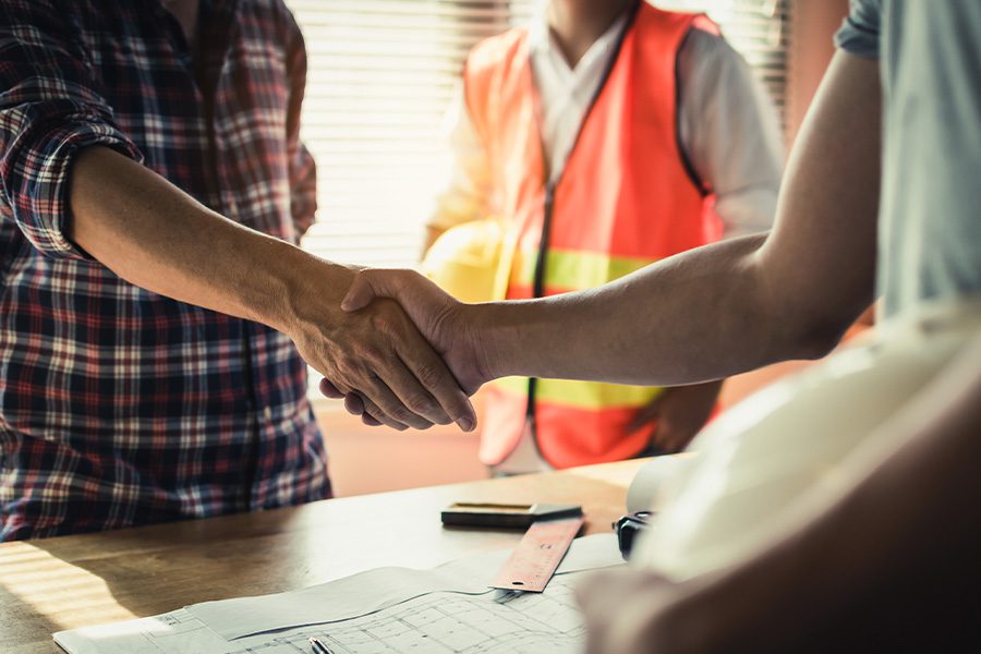 Specialized Business Insurance - Team of Construction Workers Shaking Hands after Finishing up Business Meeting at Construction Site